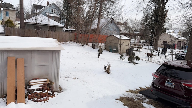 yard layered in snow with a storage shed