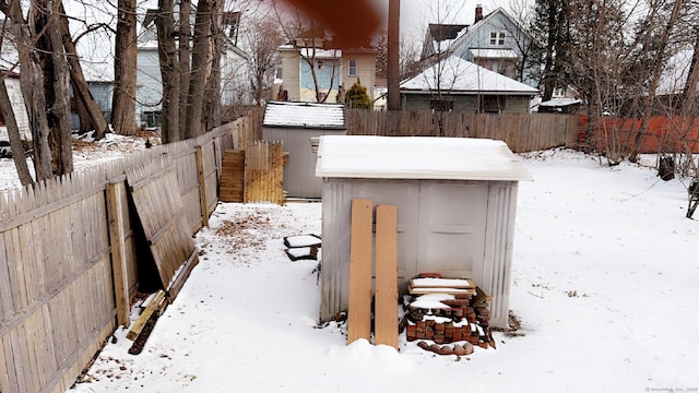 yard covered in snow with a storage shed