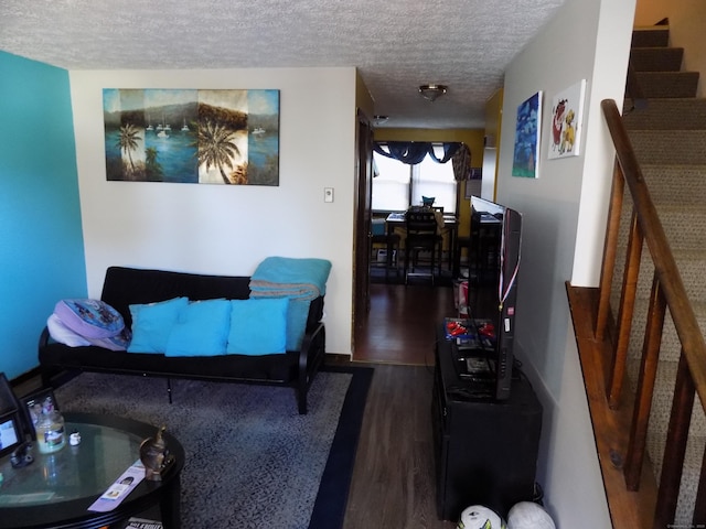 living room featuring dark wood-type flooring and a textured ceiling