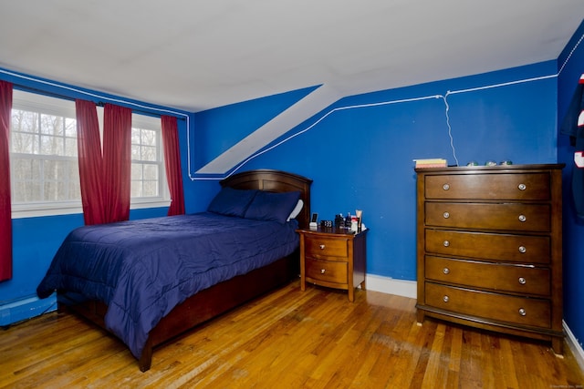 bedroom featuring hardwood / wood-style flooring and lofted ceiling