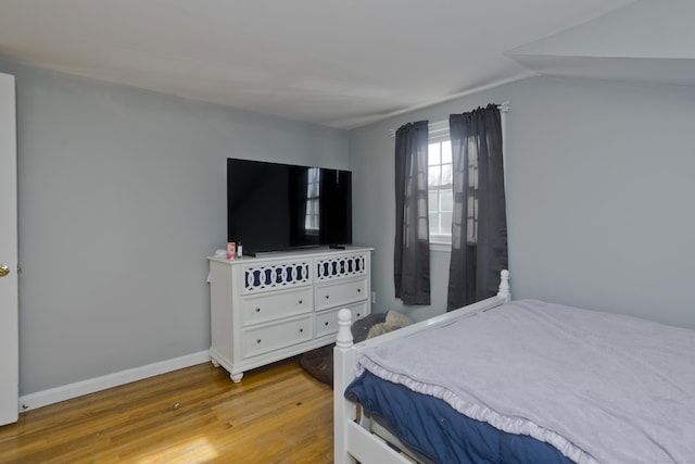 bedroom with lofted ceiling and light hardwood / wood-style flooring