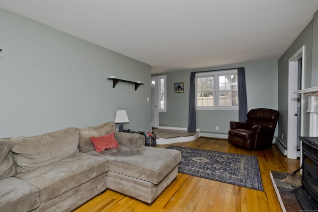 living room featuring wood-type flooring and a baseboard heating unit