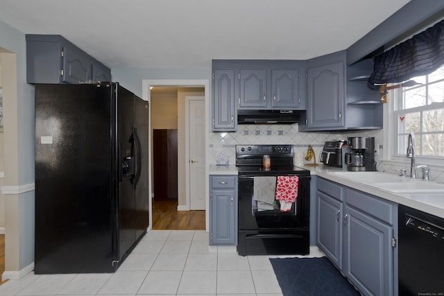 kitchen featuring tasteful backsplash, sink, light tile patterned floors, and black appliances