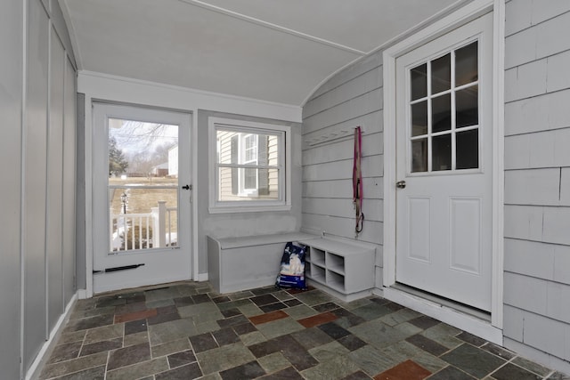 interior space featuring vaulted ceiling and wood walls