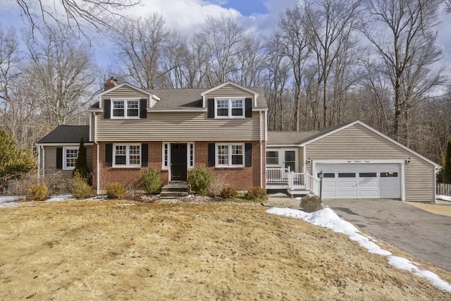 new england style home with a garage and a front lawn