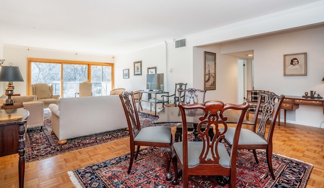 dining room featuring light parquet floors and crown molding