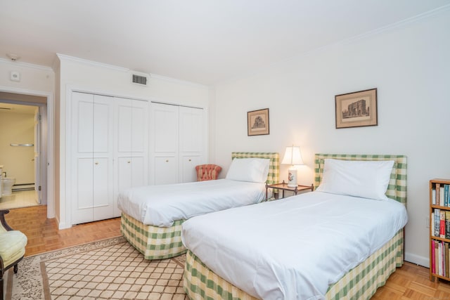 bedroom with light parquet flooring, ornamental molding, a baseboard radiator, and a closet