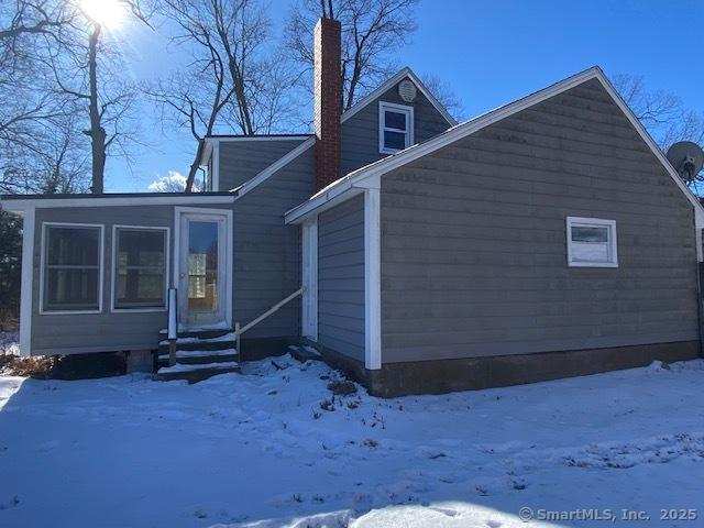 snow covered property featuring a sunroom