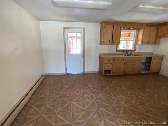 kitchen with a healthy amount of sunlight, sink, and a baseboard heating unit