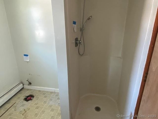 bathroom with a baseboard heating unit and a shower