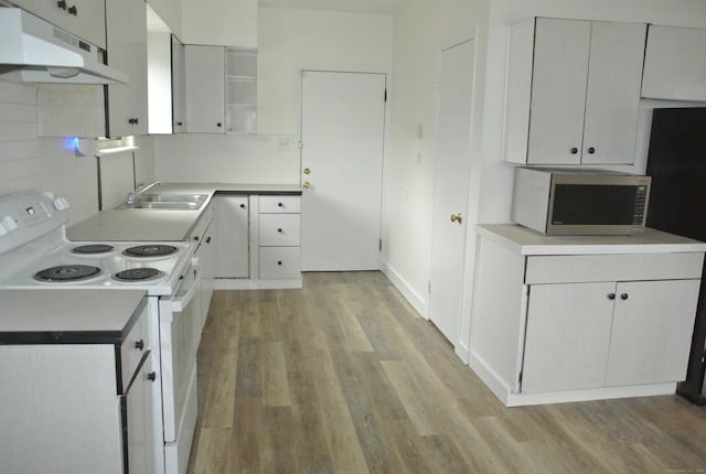 kitchen featuring stainless steel microwave, white electric range, light wood-type flooring, under cabinet range hood, and a sink