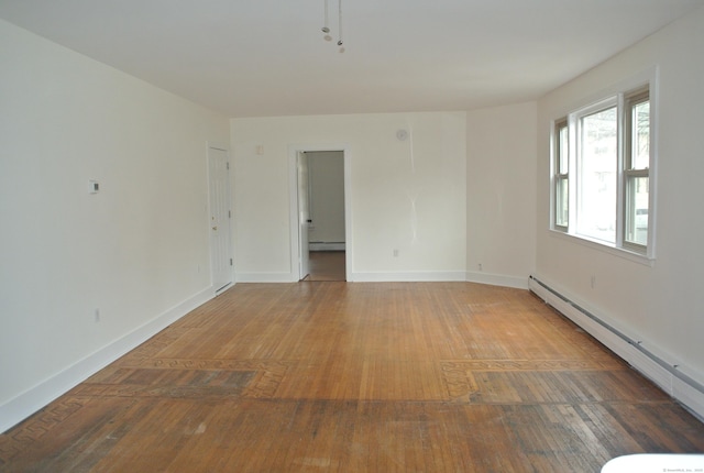 unfurnished room featuring baseboards, a baseboard heating unit, baseboard heating, and hardwood / wood-style floors