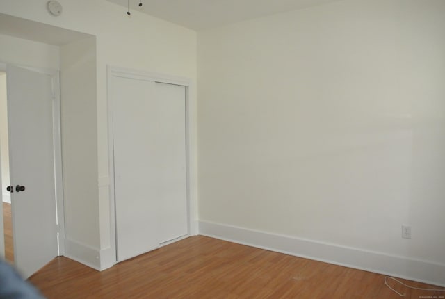 unfurnished bedroom featuring a closet and light wood-style flooring