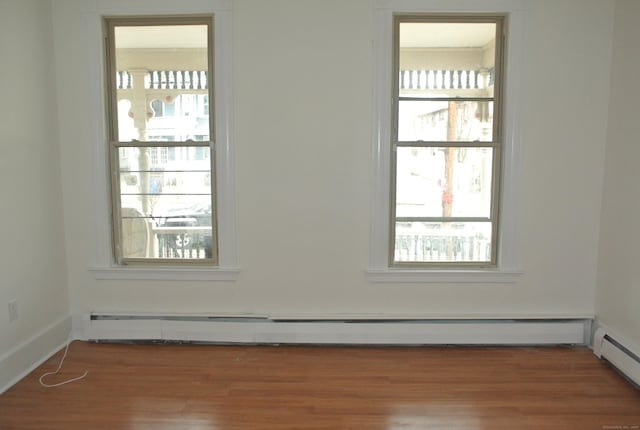 spare room with a baseboard heating unit, baseboard heating, and wood finished floors