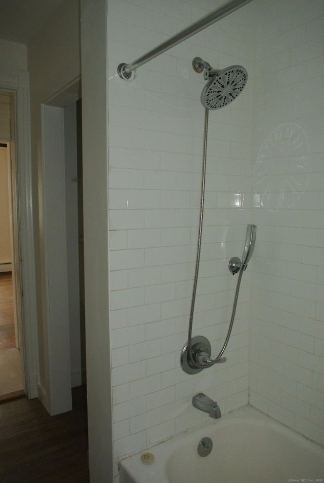 full bath featuring a baseboard radiator and bathing tub / shower combination