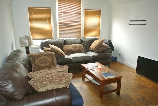 living area featuring baseboards and vaulted ceiling