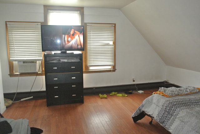 bedroom with cooling unit, lofted ceiling, and hardwood / wood-style flooring