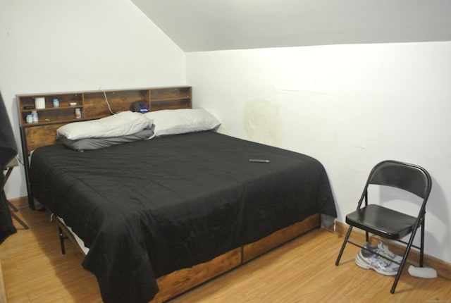 bedroom featuring lofted ceiling and wood finished floors