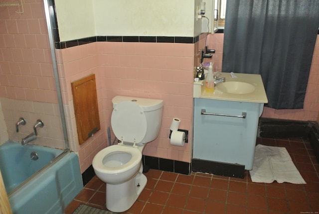 bathroom with toilet, vanity, tile walls, and tile patterned floors