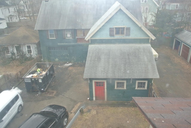 view of front of house featuring a garage and a shingled roof