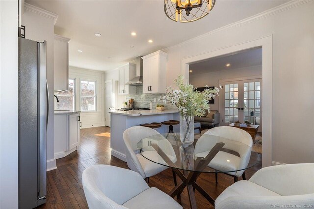 dining space with crown molding, dark hardwood / wood-style floors, sink, and french doors