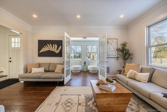 living room with dark wood-type flooring, ornamental molding, and french doors