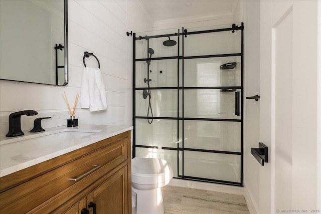 bathroom with vanity, hardwood / wood-style flooring, ornamental molding, and tiled shower