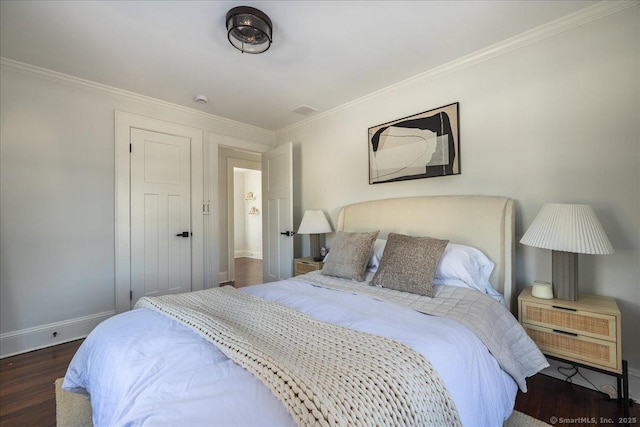 bedroom with ornamental molding and dark hardwood / wood-style floors