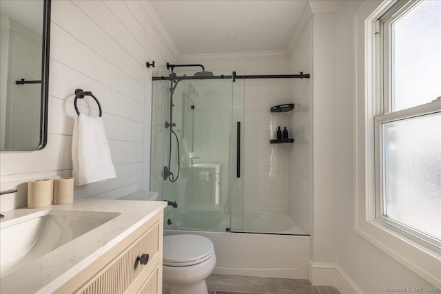 full bathroom featuring toilet, ornamental molding, vanity, and bath / shower combo with glass door