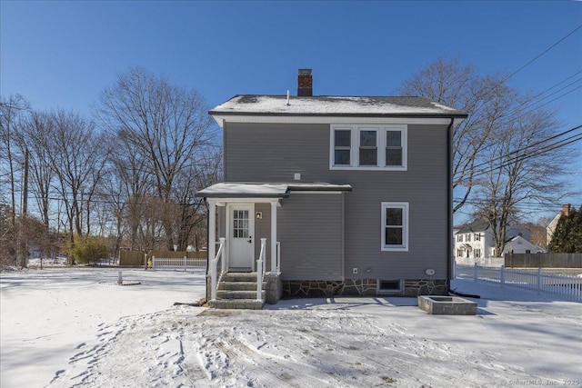 view of snow covered rear of property