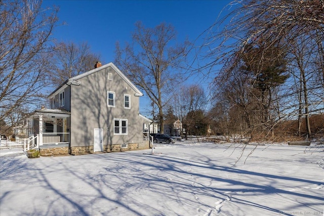 view of snow covered exterior with covered porch