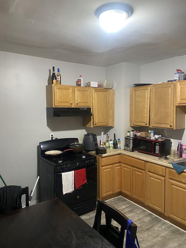 kitchen featuring light hardwood / wood-style flooring and black gas range