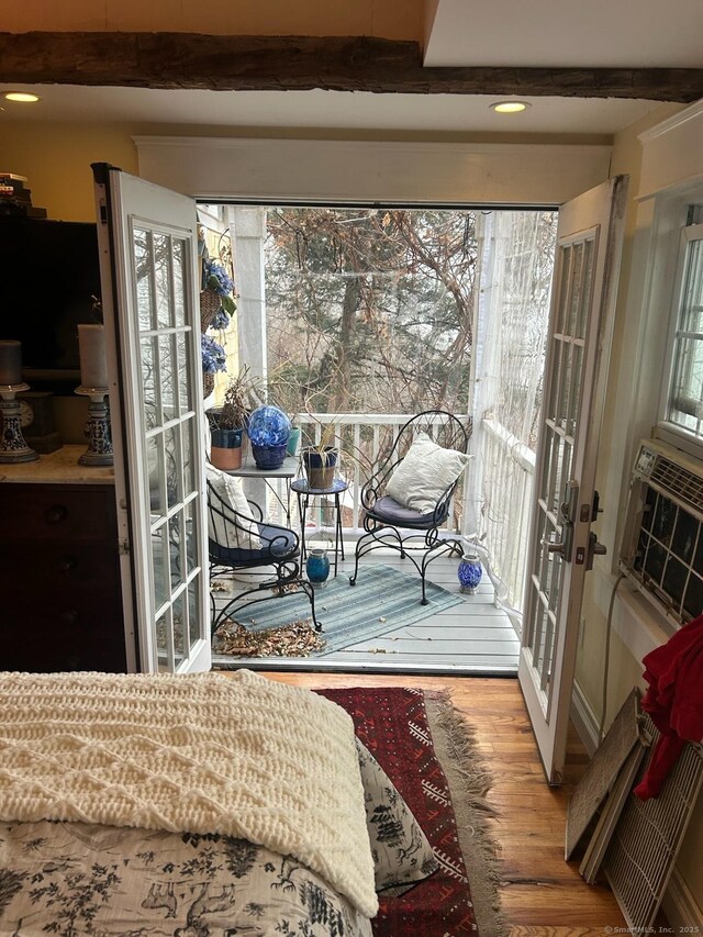 interior space featuring cooling unit, wood finished floors, french doors, and beam ceiling