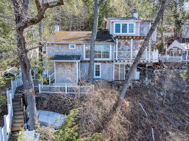 view of front of house with a chimney, a wooden deck, and stairway