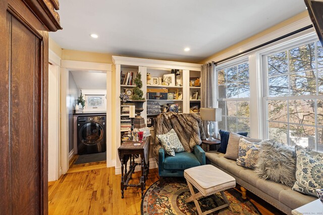 living room with light wood-style flooring, recessed lighting, and washer / dryer