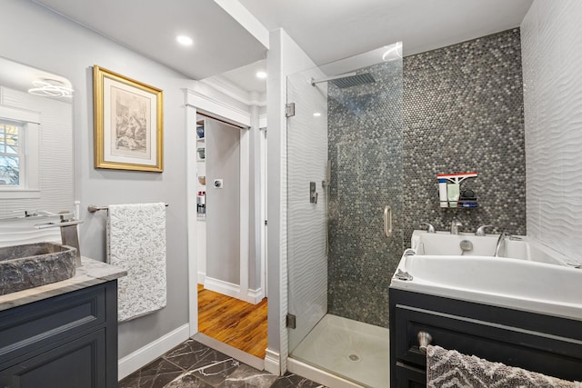 full bathroom with marble finish floor, vanity, baseboards, and a shower stall