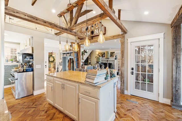 kitchen featuring high end range, under cabinet range hood, light stone counters, hanging light fixtures, and a center island