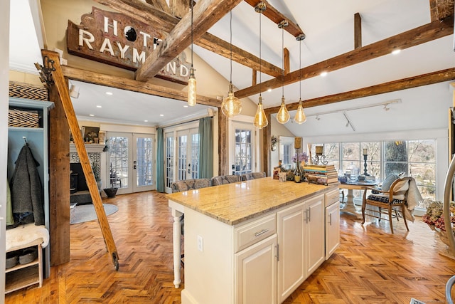 kitchen with hanging light fixtures, open floor plan, beam ceiling, and a kitchen island