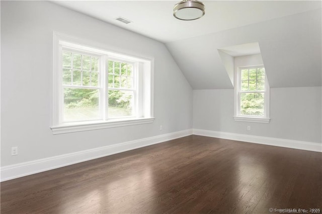 additional living space with dark wood-type flooring and vaulted ceiling