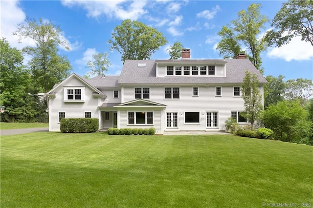 rear view of property with a lawn