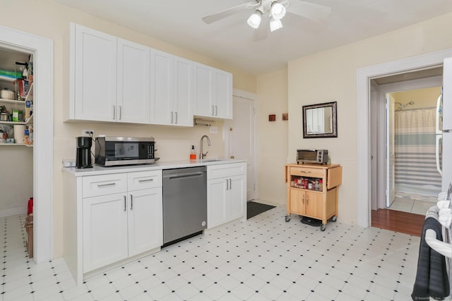 kitchen with appliances with stainless steel finishes, white cabinets, light countertops, and a sink