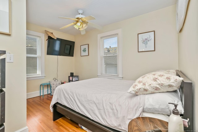 bedroom featuring ceiling fan, baseboards, and wood finished floors