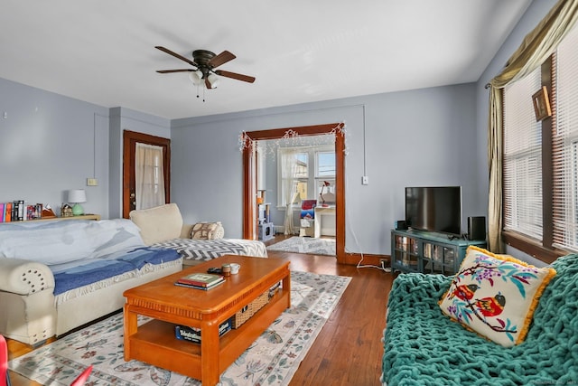 living room with ceiling fan, dark wood-style flooring, and baseboards