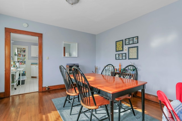 dining room featuring dark wood-type flooring and baseboards