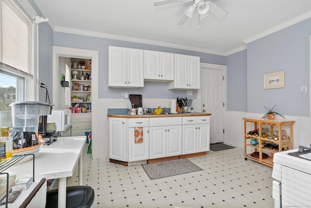 kitchen with light floors, ornamental molding, light countertops, and white cabinetry