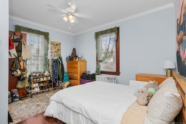 bedroom featuring radiator heating unit, ornamental molding, ceiling fan, and wood finished floors