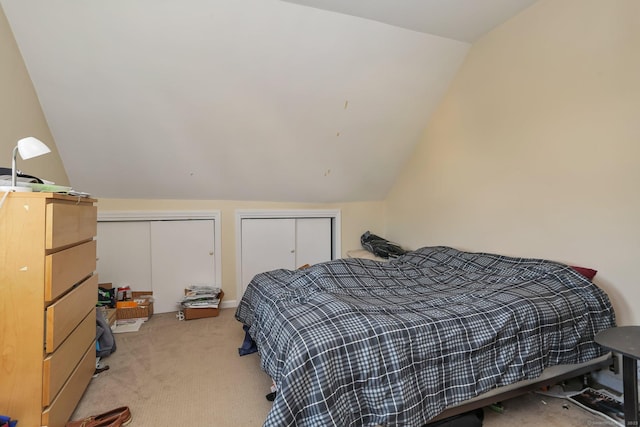 bedroom with vaulted ceiling and light colored carpet