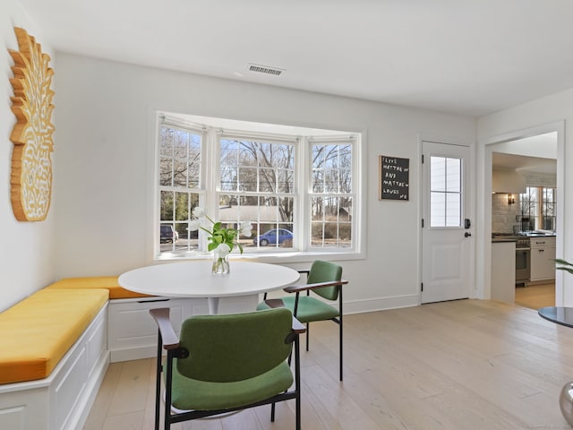 dining room with light wood-type flooring, baseboards, and visible vents