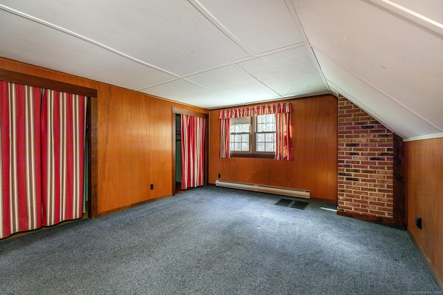 additional living space with a baseboard radiator, vaulted ceiling, wooden walls, and carpet flooring