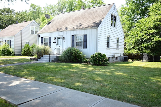 cape cod-style house featuring central AC and a front lawn